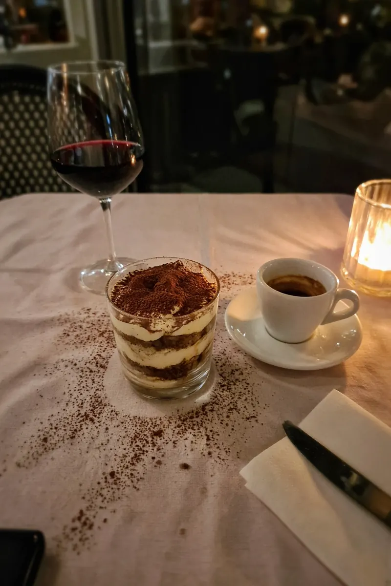 Tiramisù appena servito a un tavolo di ristorante, foto da telefono